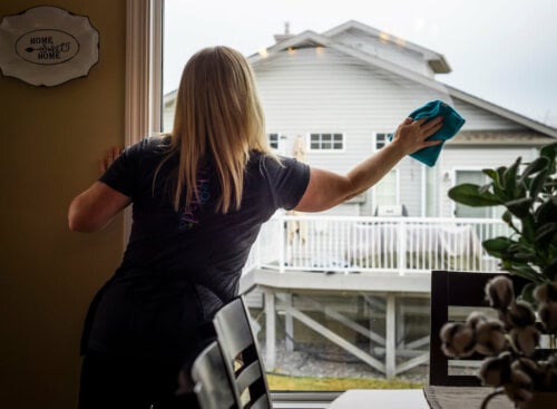 woman cleaning dining room window