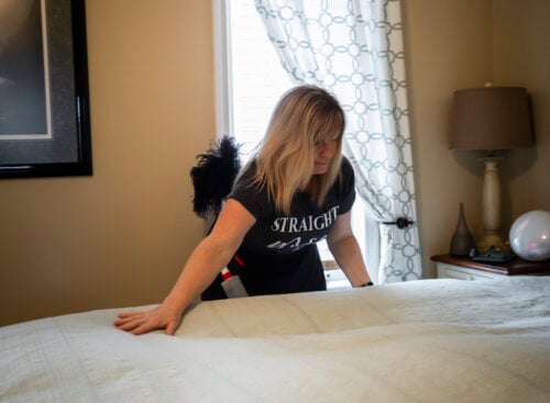 house cleaner making a bed