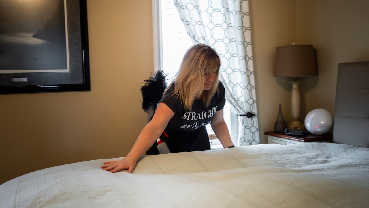 house cleaner making a bed