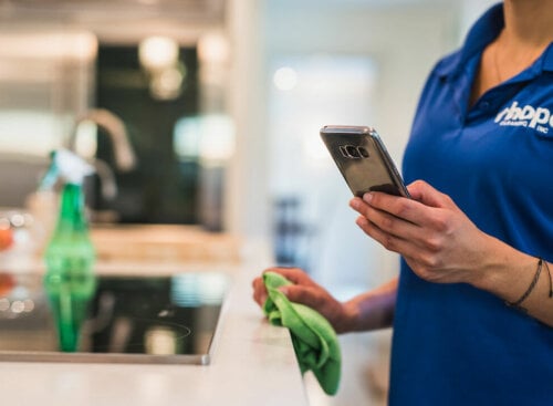 Cleaner holding a cell phone