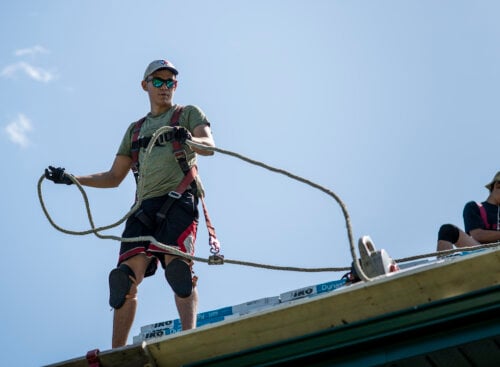 two men working on top of a roof
