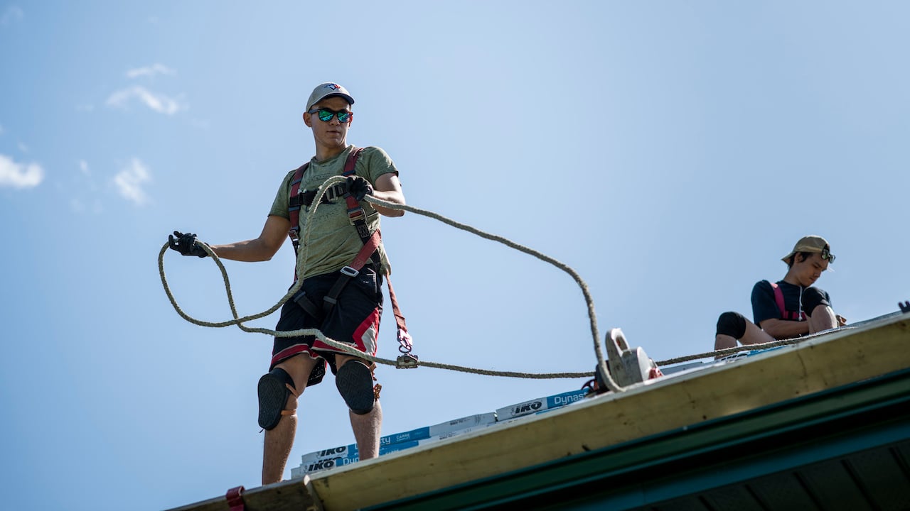 two men working on top of a roof