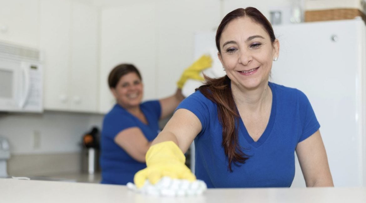 how to start a commercial cleaning business: women cleaning office kitchen