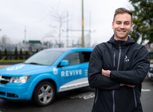 man standing in front of a company vehicle