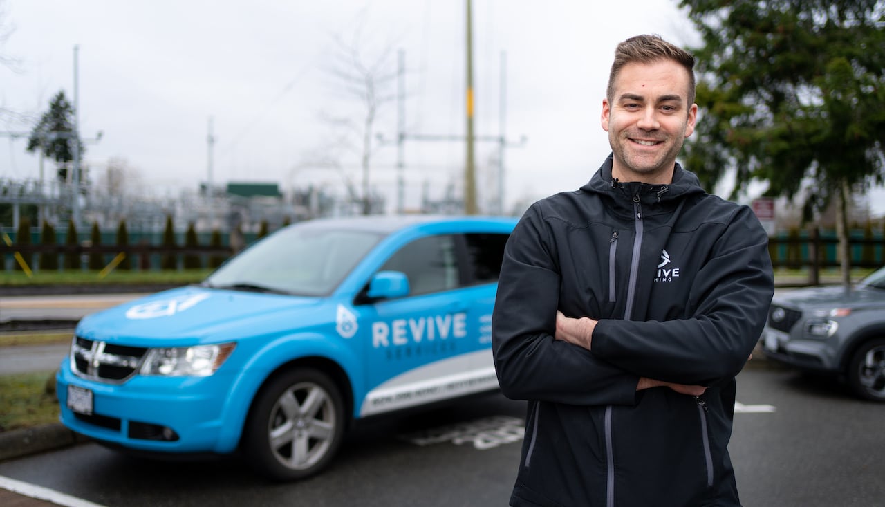 man standing in front of a company vehicle