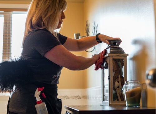 woman cleaning a lantern on a table