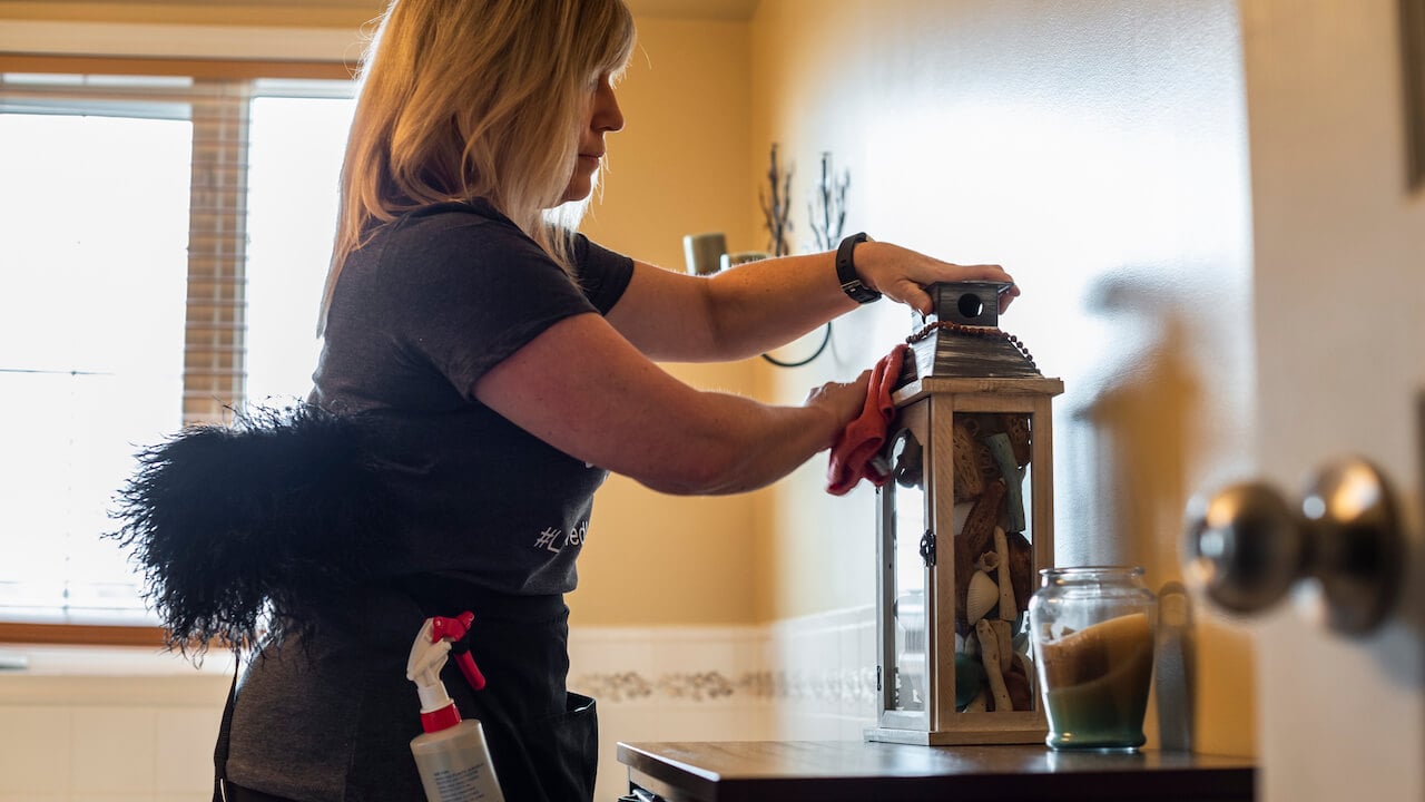 woman cleaning a lantern on a table