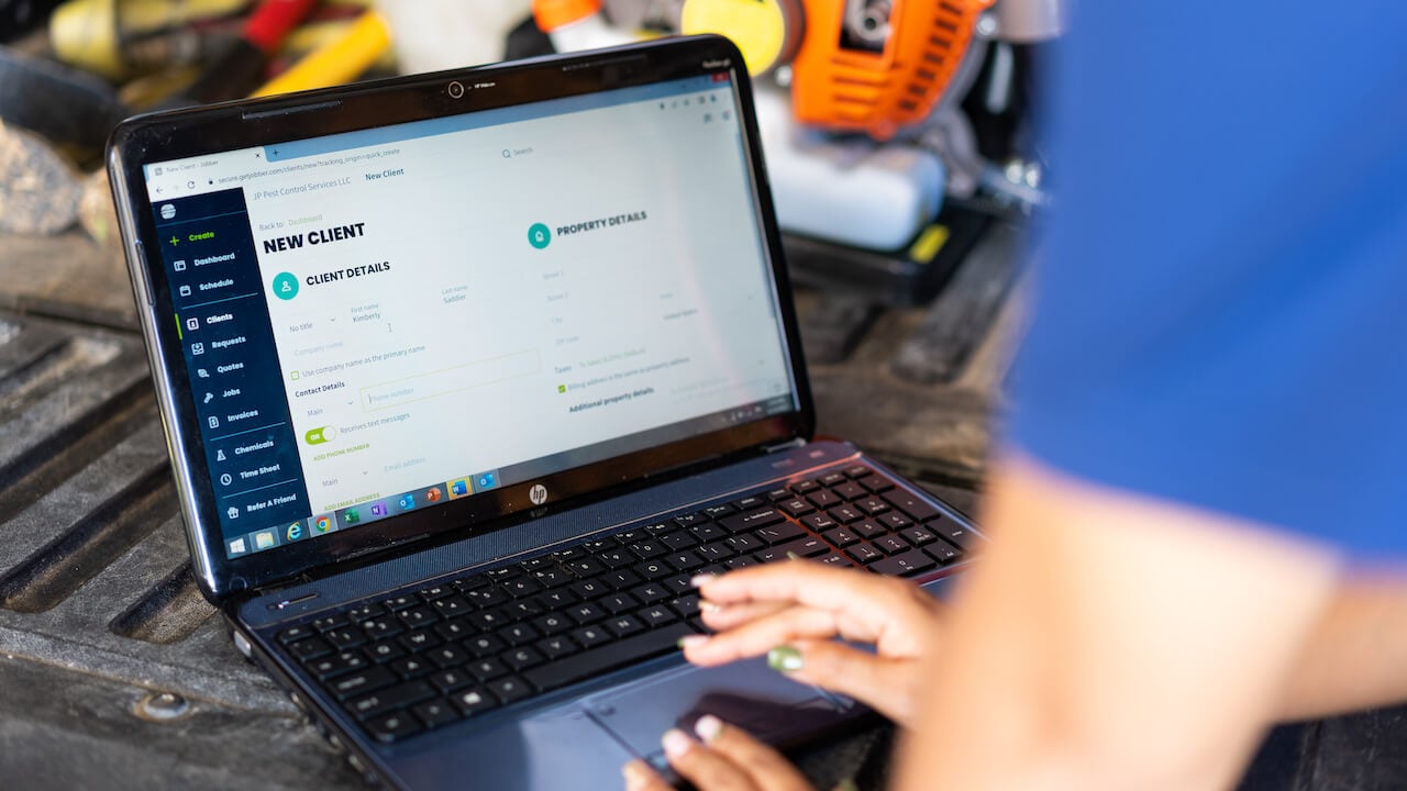 Photo of a service business owner adding a new customer to the Jobber CRM