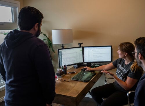 Photo of three home service workers gathered around a computer to write an SOP (Standard Operating Procedure)