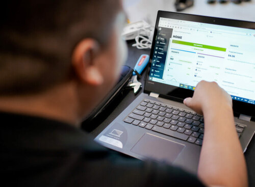Photo of a small business owner using the Jobber CRM and payment software to offer invoice financing to customers