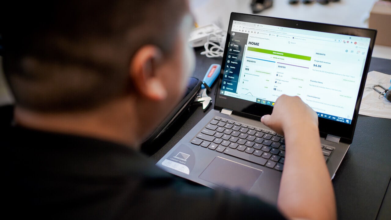 Photo of a small business owner using the Jobber CRM and payment software to offer invoice financing to customers