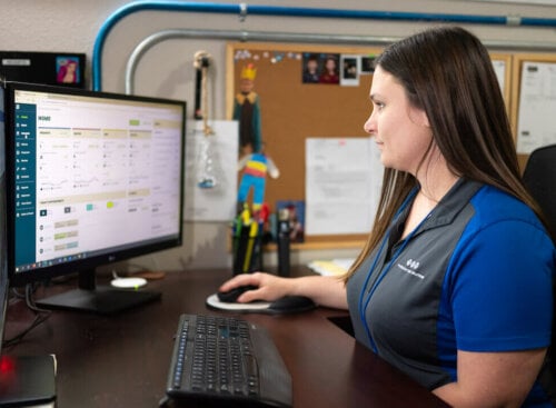 Photo of a home service business owner checking her CRM to see business revenue and profit