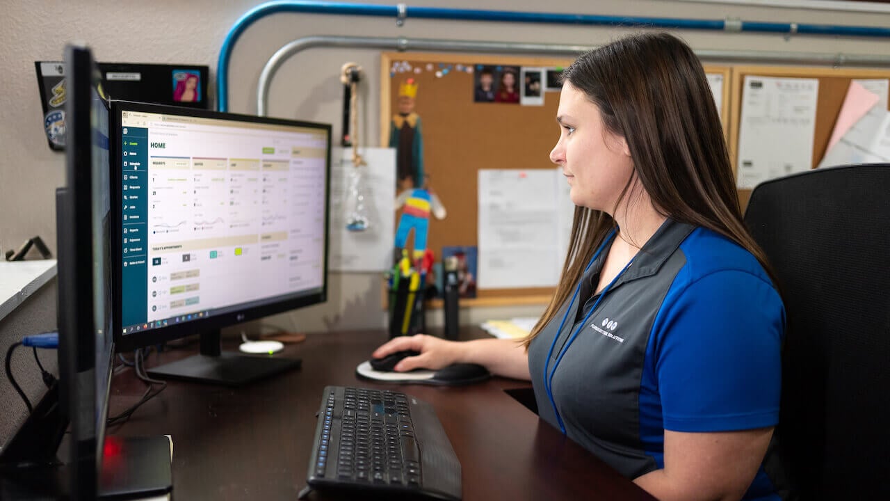 Photo of a home service business owner checking her CRM to see business revenue and profit