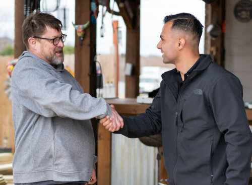 Service business owner shaking hands with a customer
