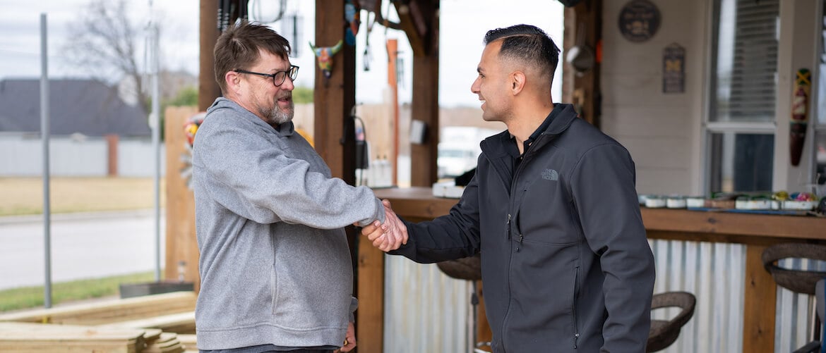 Service business owner shaking hands with a customer