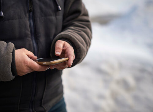 Photo of a home service entrepreneur using recurring payment processing on an app to collect payment for jobs