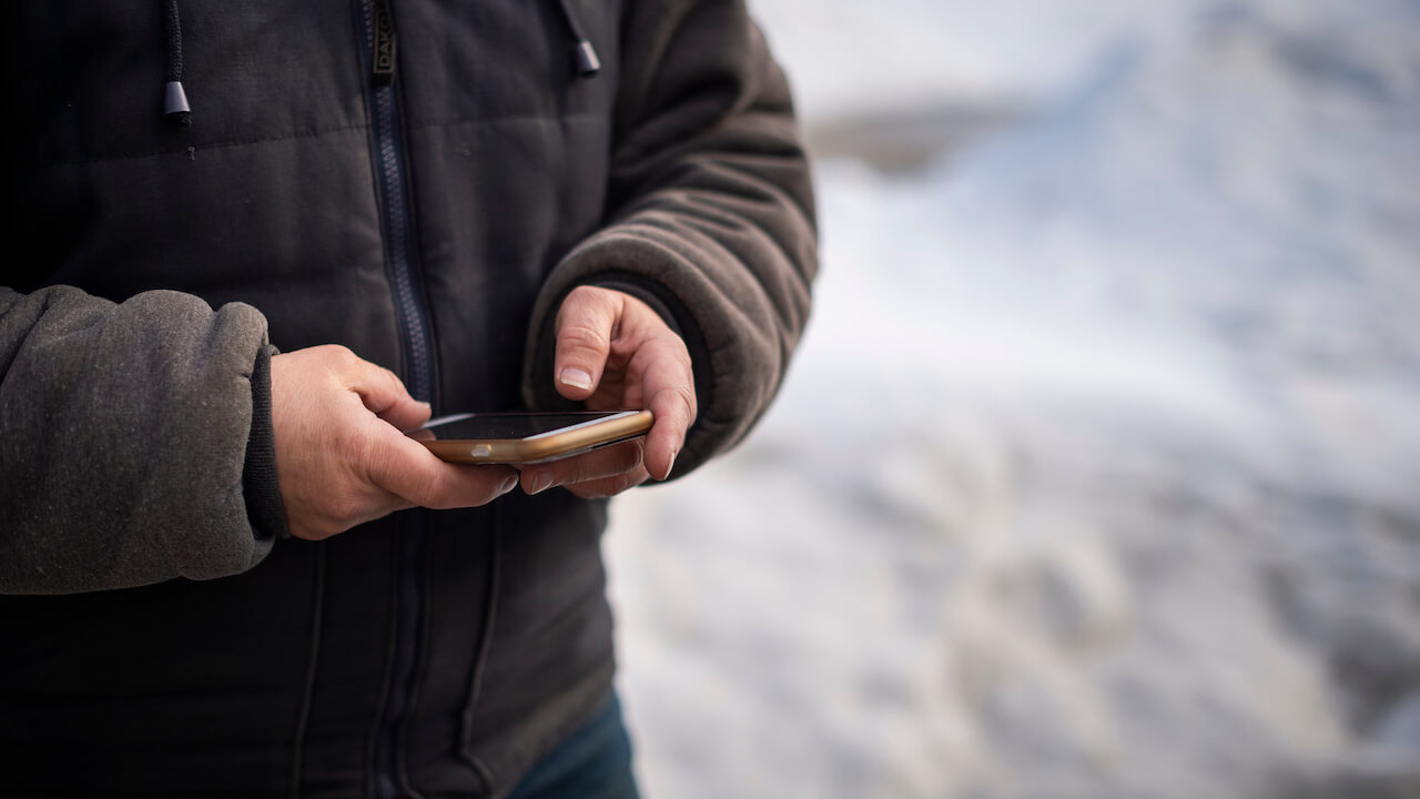Photo of a home service entrepreneur using recurring payment processing on an app to collect payment for jobs