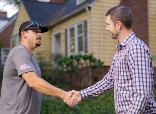Photo of a home service contractor shaking hands with a customer after closing a deal with a binding estimate