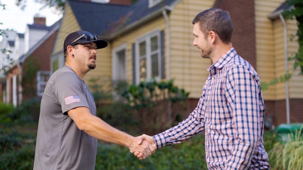 Photo of a home service contractor shaking hands with a customer after closing a deal with a binding estimate
