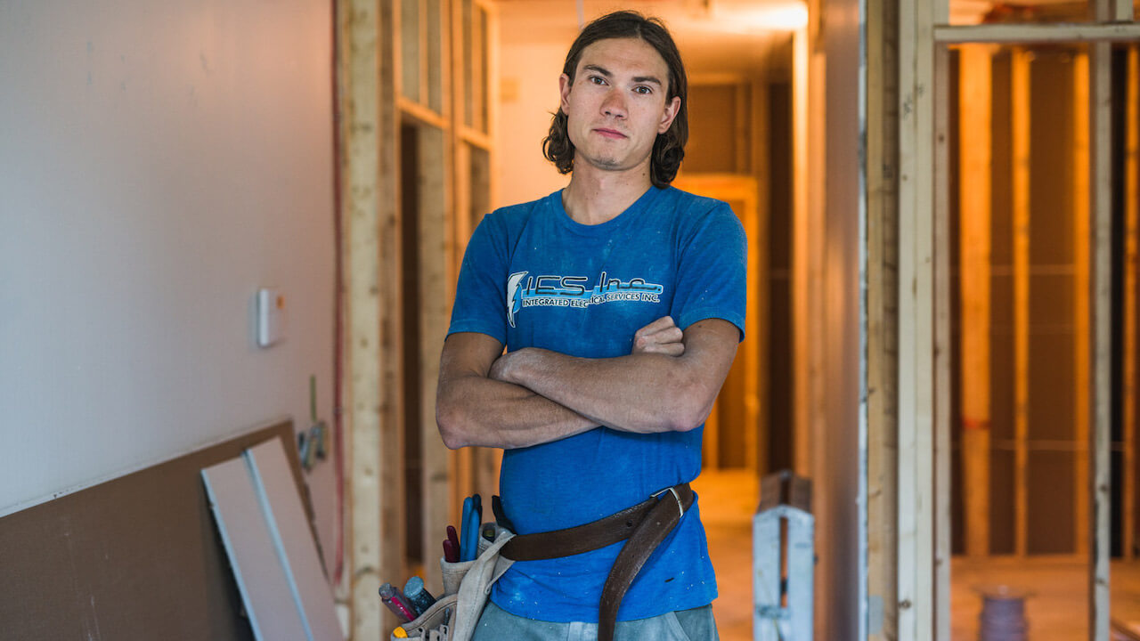 electrical worker standing in a framed home