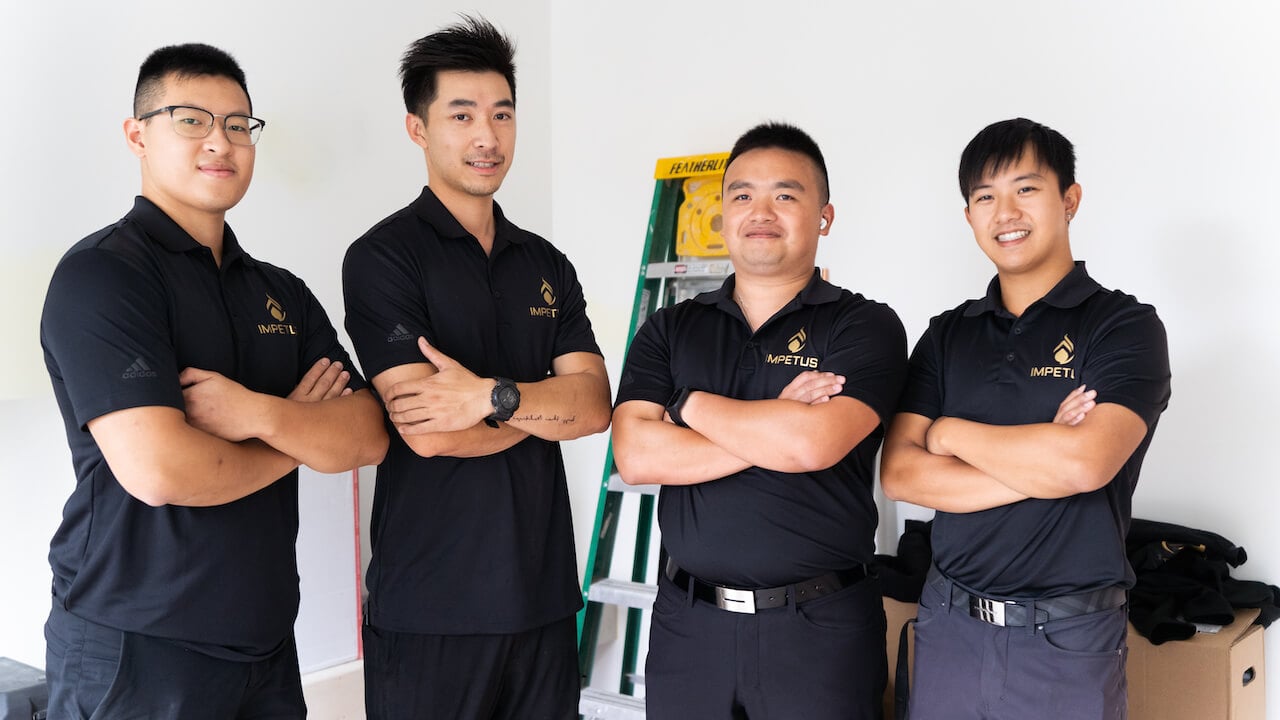 four plumbing employees standing in a line