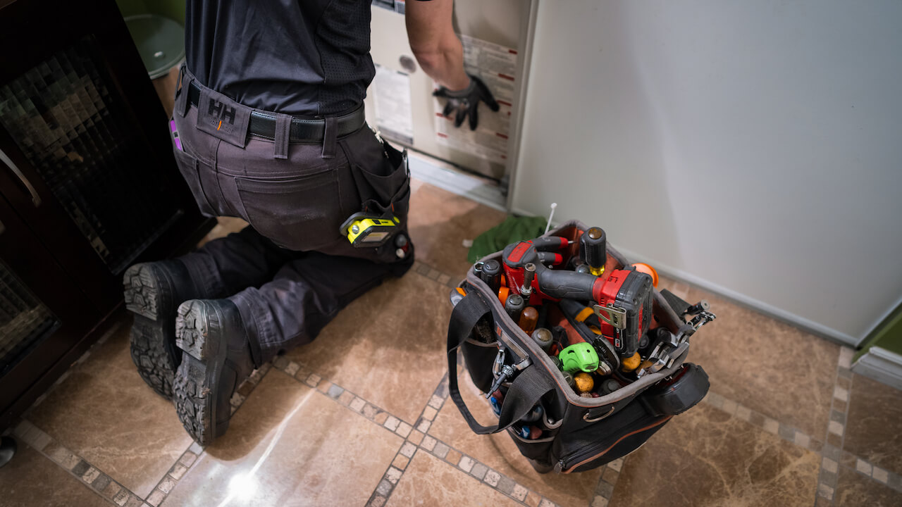 Photo of an HVAC technician servicing equipment and following an HVAC inspection checklist