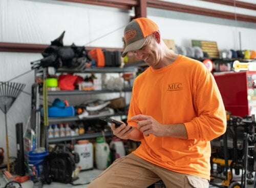 image of lawn care service provider working on mobile device