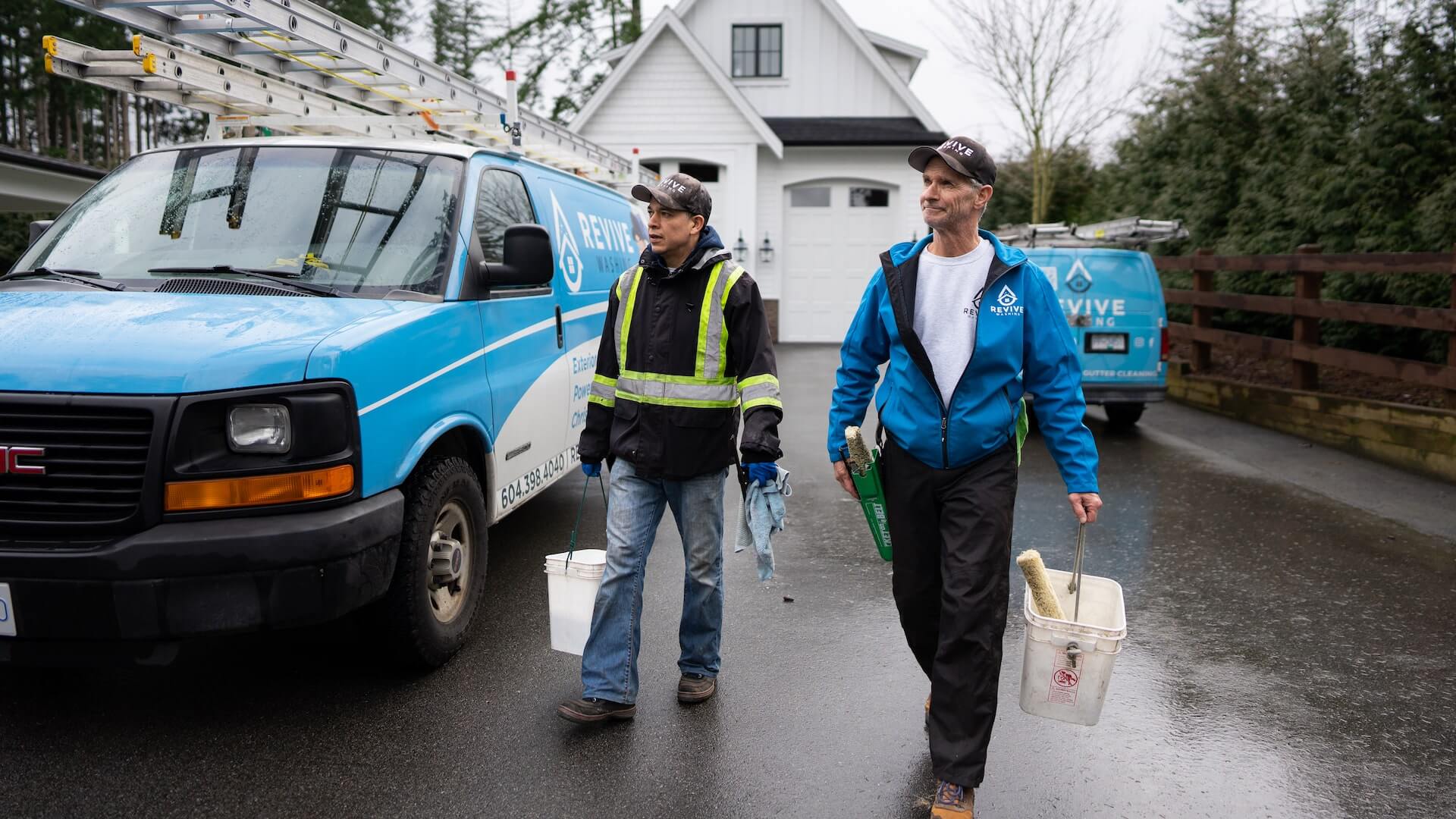 image of two members of Revive Washing on the job site with buckets