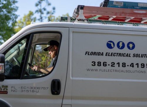 worker sitting in business vehicle with electrical company name on the side