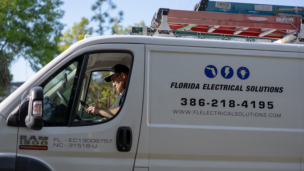 worker sitting in business vehicle with electrical company name on the side
