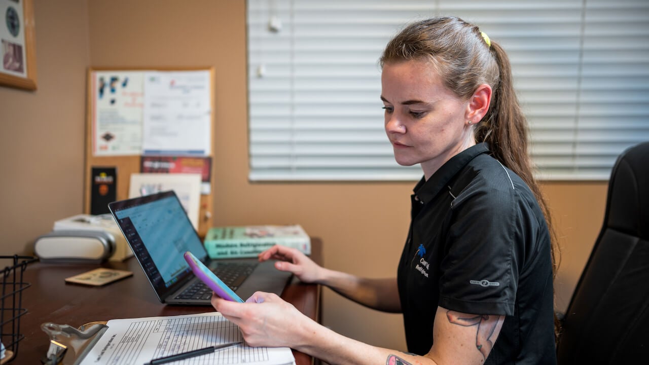 Business owner at a desk calculating HVAC business profit margins