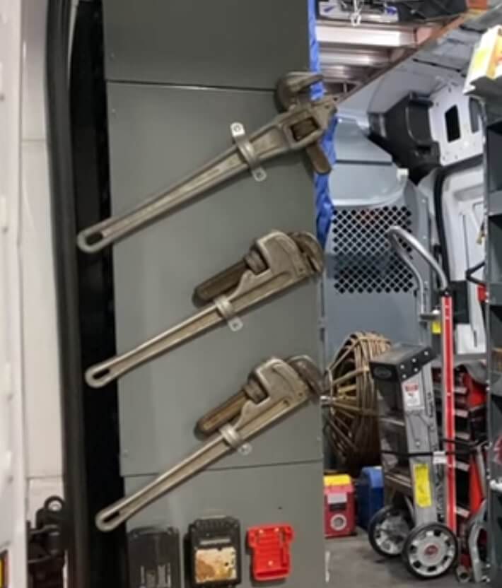 Wrench holders bolted to an HVAC van shelving unit