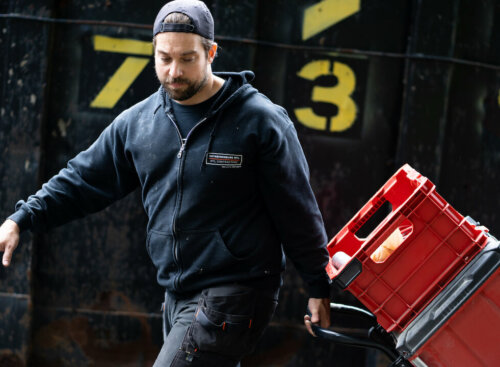 junk removal worker pulling dolly with items on top