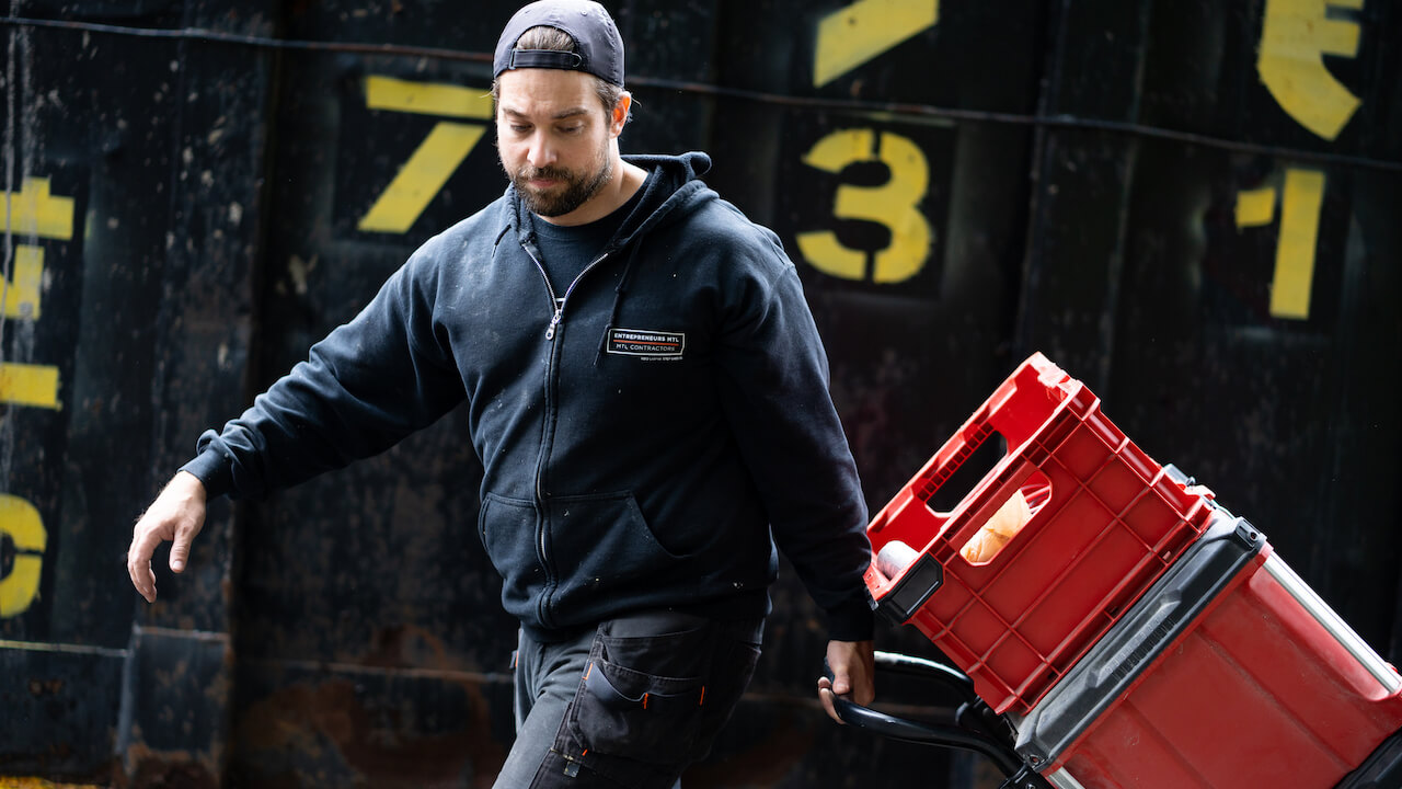 junk removal worker pulling dolly with items on top