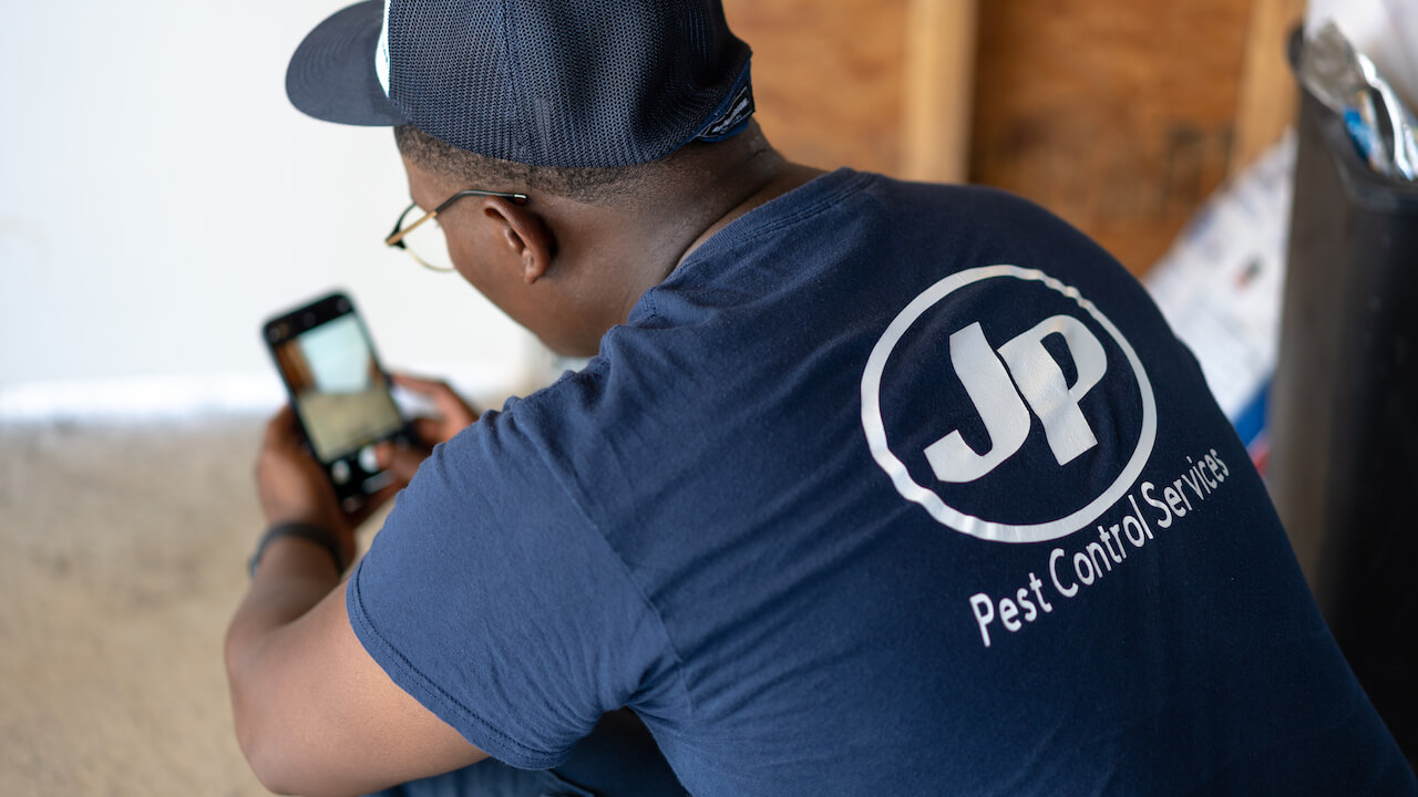 worker wearing shirt with pest control company name on the back