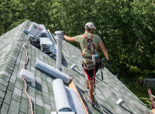 how to start a roofing business - roofer standing on top of a home's roof