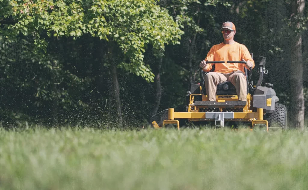 Lawn care professional mowing a lawn after using lawn care business software