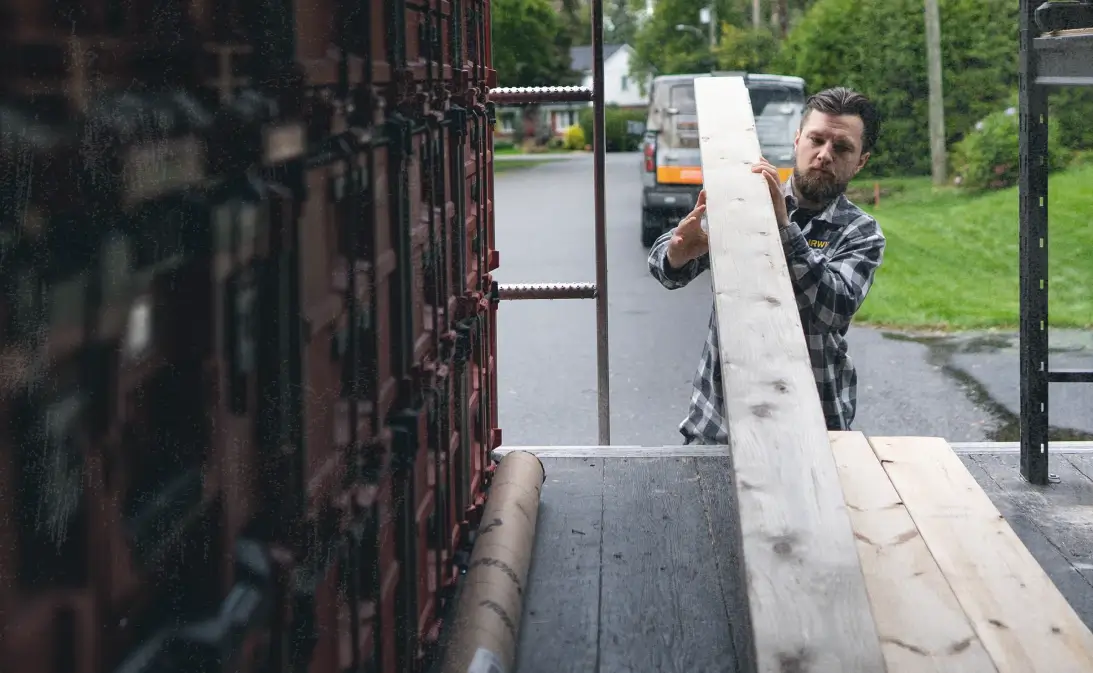 image of contractor unloading 2x4s after using general contractor business software
