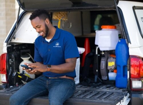 home service business owner using mobile software to manage business