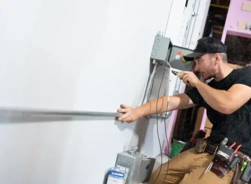 image of electrical contractor working on electrical panel after using Jobber's electrical contractor software