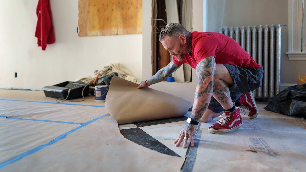 flooring company names - man removing paper wrapping from marble floor
