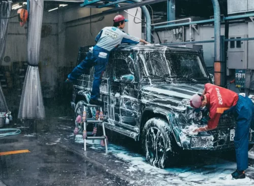 image of auto detailers washing car after using Jobber's auto detailing software