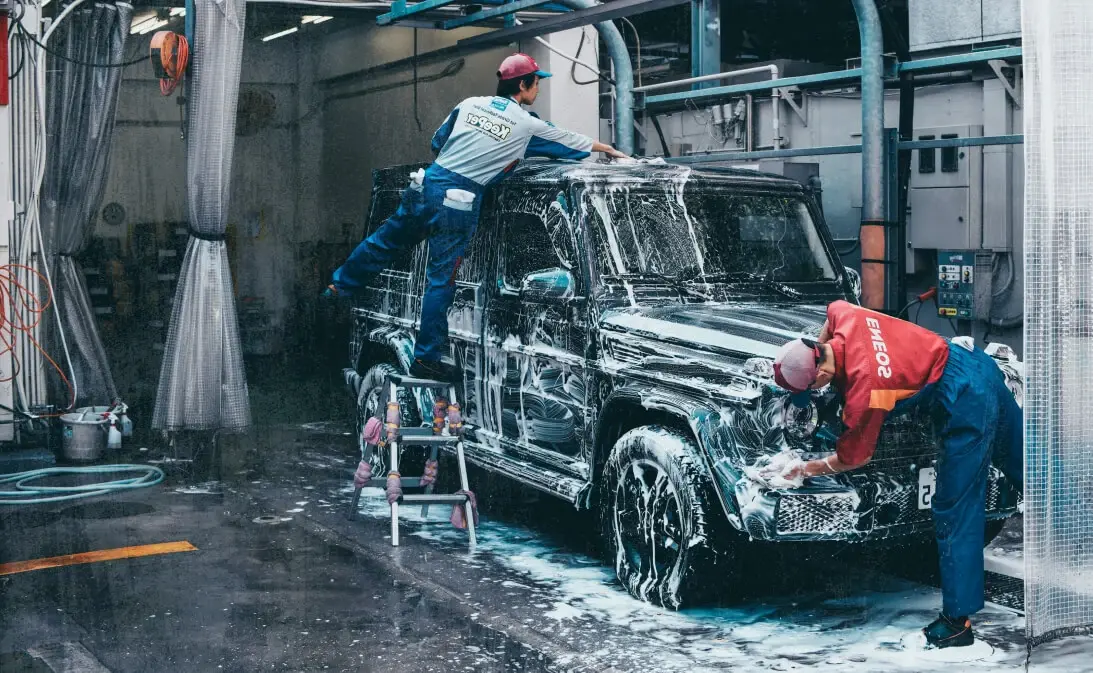 image of auto detailers washing car after using Jobber's auto detailing software
