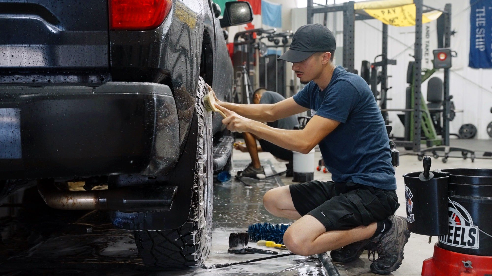 image of auto detailer cleaning the tire and rim of a car