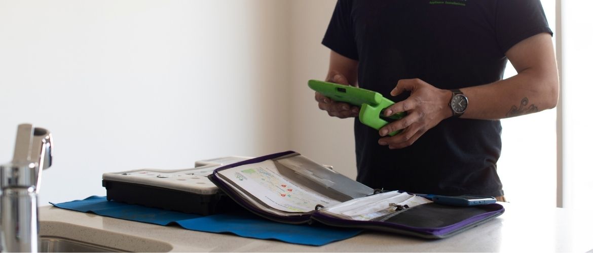 Appliance repair service provider using software on tablet to manage his business operations