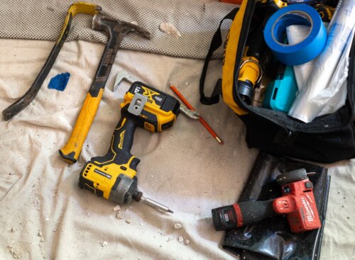 Assorted hand and power tools on a drop cloth.