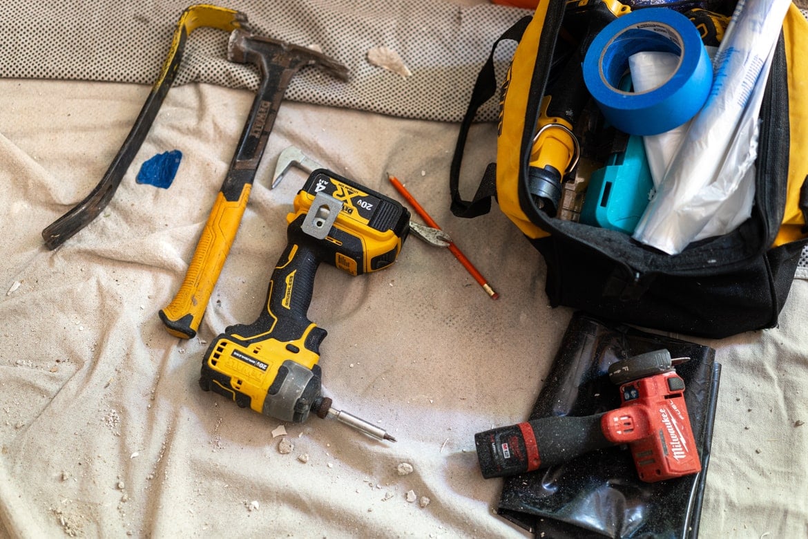 Assorted hand and power tools on a drop cloth.