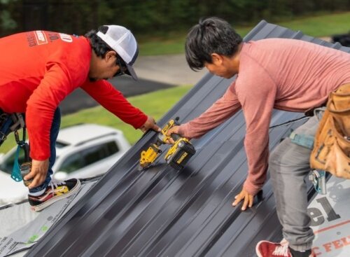 Two roofing contractors working on a job.