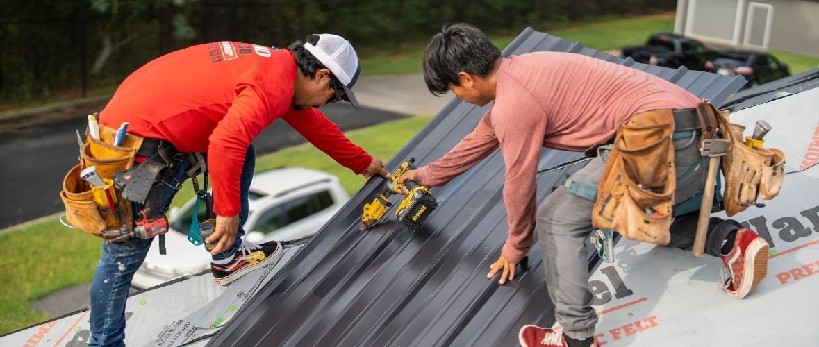 Two roofing contractors working on a job.