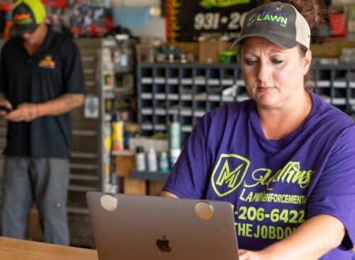 Woman sitting down and typing on her laptop